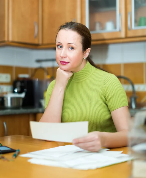 Dona de casa positiva olhando através de contas — Fotografia de Stock