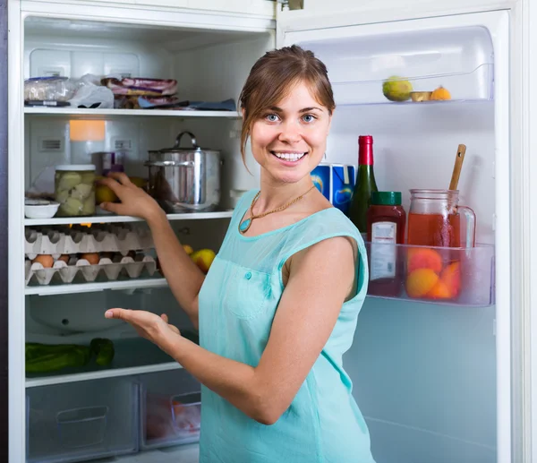 Menina arrumando espaço de prateleiras frigorífico — Fotografia de Stock