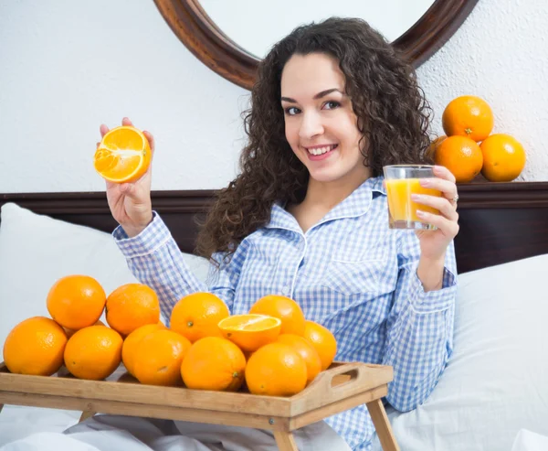 Girl with ripe oranges and glass — Stock Photo, Image