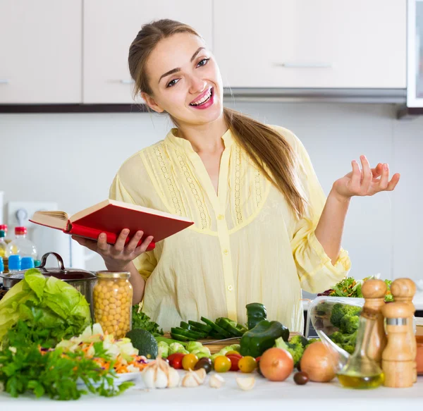 Menina aprendendo nova receita do livro de receitas — Fotografia de Stock