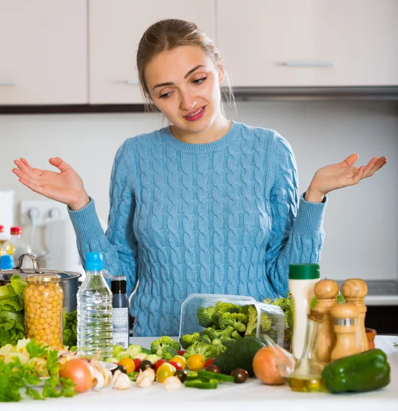 Meisje kijkend naar groenten binnenshuis — Stockfoto