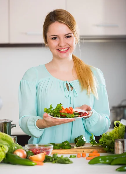 Kvinna med vegetabiliska mix leende hemma — Stockfoto