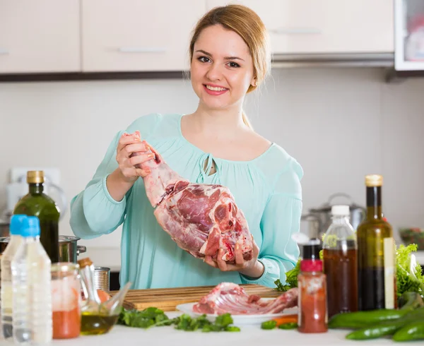 Young woman cooking lamb for dinner — Stock Photo, Image