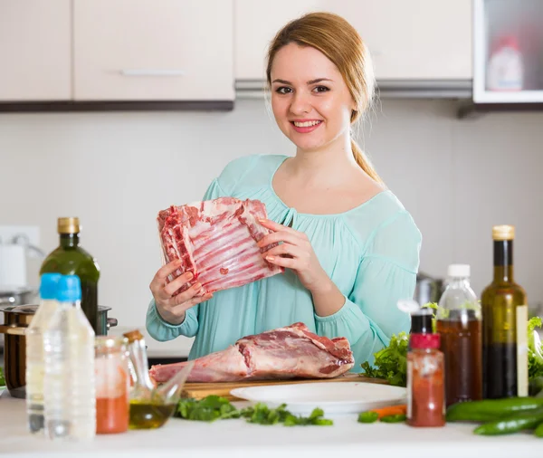 Jeune femme cuisine agneau pour le dîner — Photo