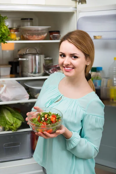 Long-haired woman arranging space in fridge — Stock Photo, Image