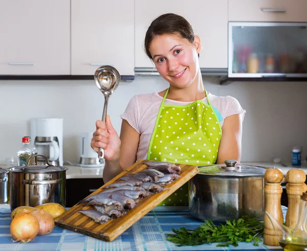 Woman cooking stew with sardines — Stock Photo, Image