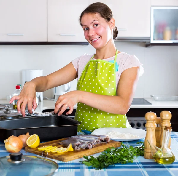 Woman putting sprats in baking — Stock Photo, Image