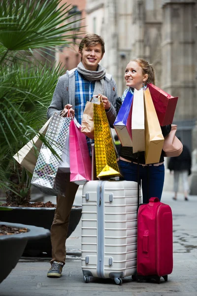 Couple of travellers with shopping bags — Stock Photo, Image