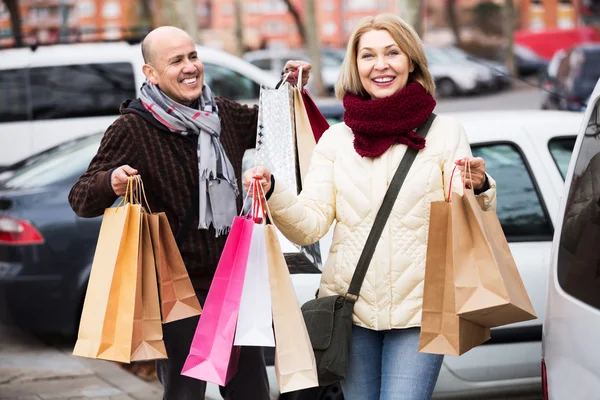 Aposentados casal com sacos de compras — Fotografia de Stock