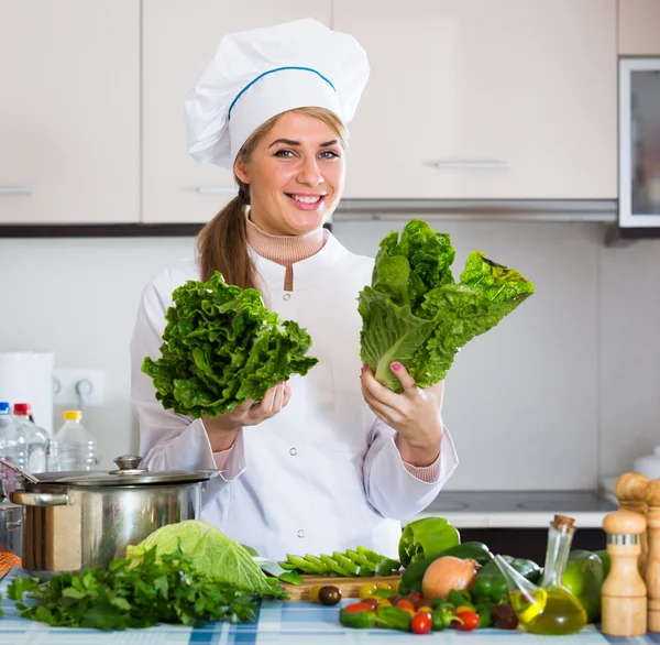 Chef com alface fresca posando na cozinha — Fotografia de Stock