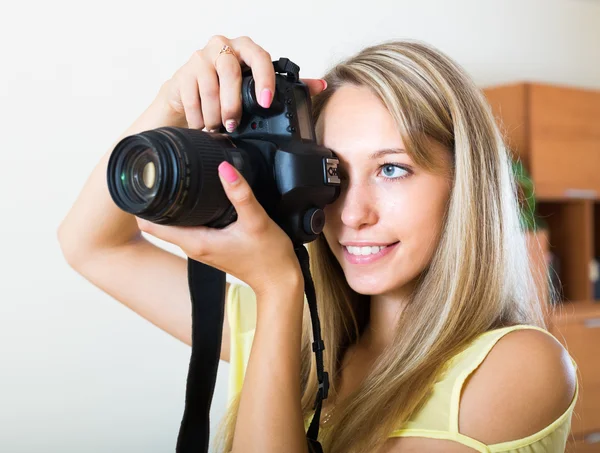 Chica sonriente trabajando con la cámara fotográfica — Foto de Stock