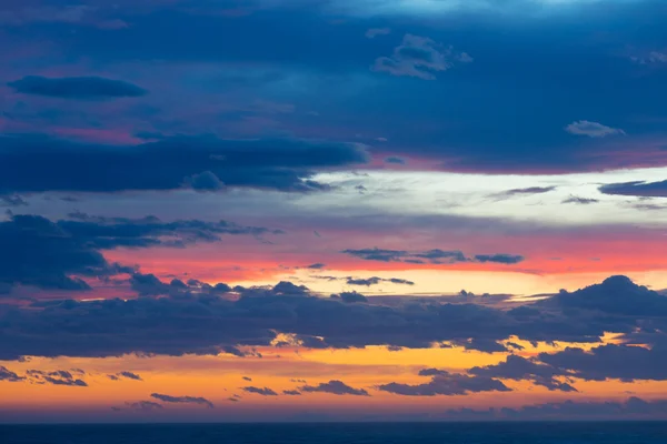 Färgglad solnedgång med moln och solstrålar — Stockfoto