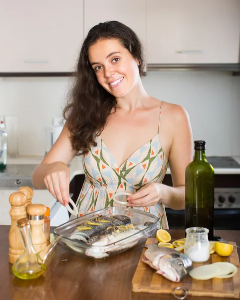 Mujer cocinando pescado en casa cocina — Foto de Stock