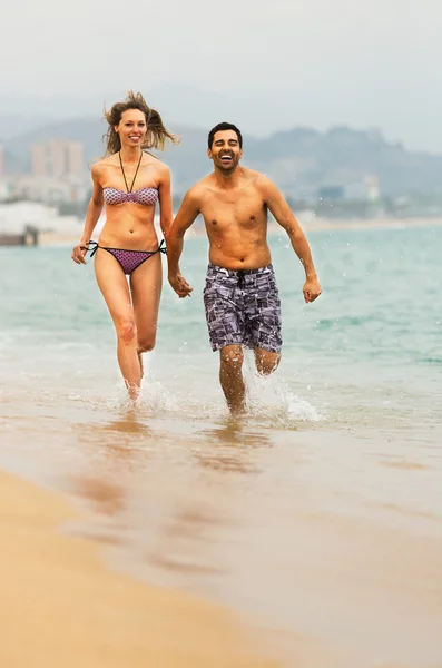 Casal jovem corre perto do mar — Fotografia de Stock