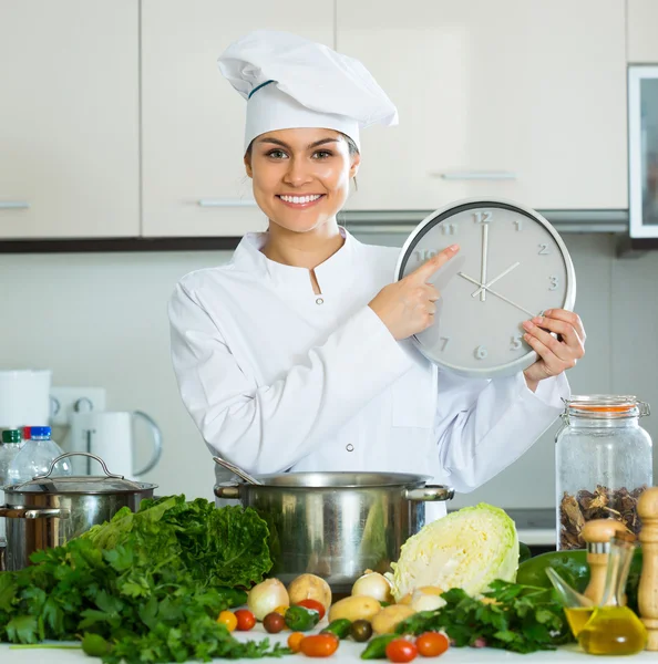 Vrouw met klok in de keuken — Stockfoto
