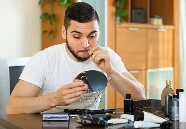 Man tar bort hår med pincett — Stockfoto