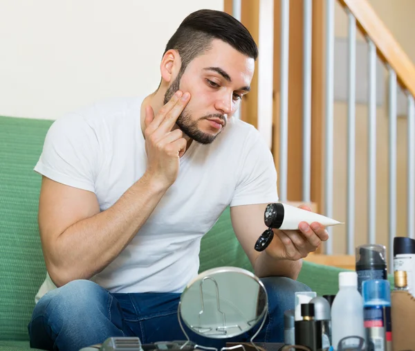 Man tillämpar ansiktskräm — Stockfoto