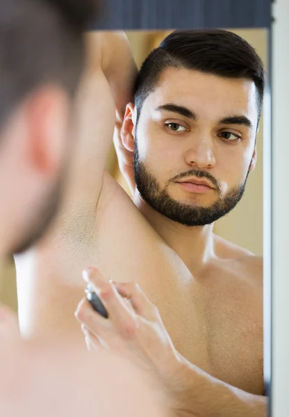 Hombre aplicando desodorante — Foto de Stock