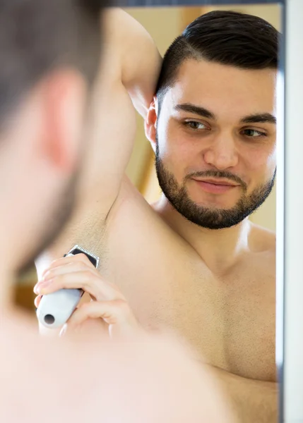 Young guy shaving armpit