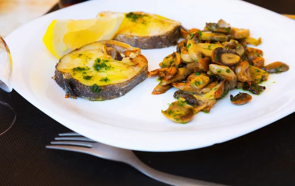 Fish with mushrooms on plate — Stock Photo, Image