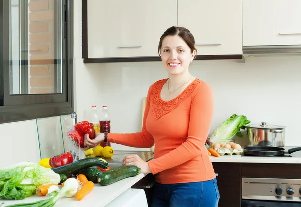 Positiva hemmafru tvätta grönsaker — Stockfoto