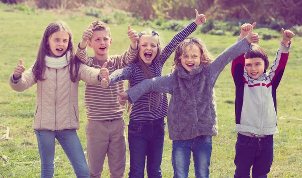 Kids showing thumbs up outdoors — Stock Photo, Image