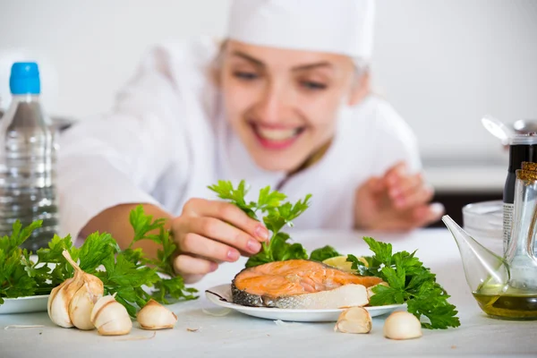 Unga kvinnliga chef med stekt fisk — Stockfoto