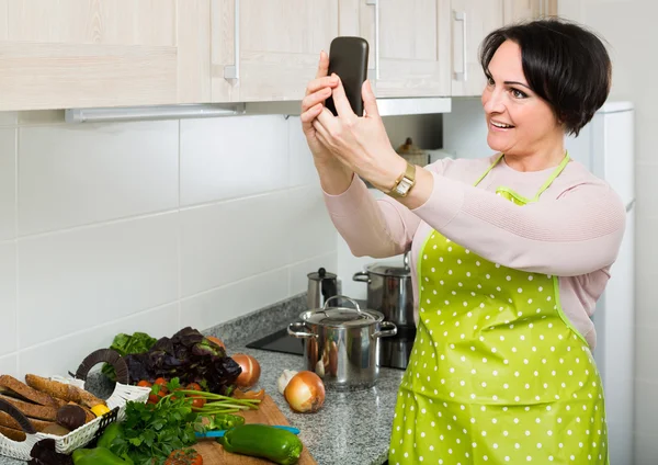 Hemmafru i förkläde att göra selfie — Stockfoto