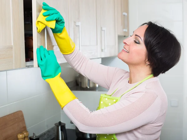 Midden leeftijd vrouw meubels afstoffen — Stockfoto