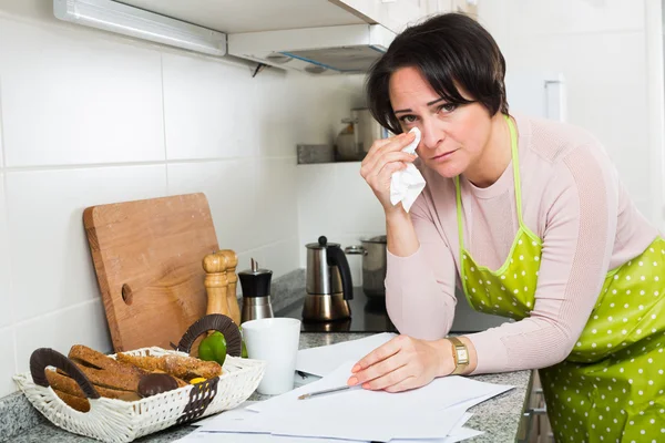 Triest huisvrouw lezen van rekeningen en huilen — Stockfoto