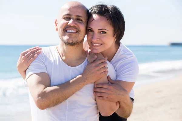 Casal segurando uns aos outros na praia — Fotografia de Stock