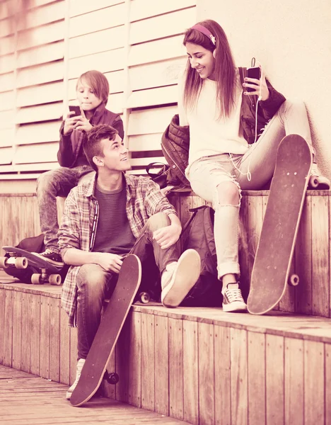 Happy teens playing on smarthphones — Stock Photo, Image