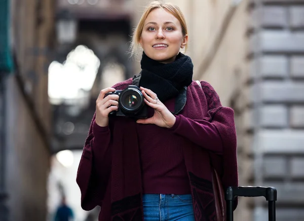 Girl holding camera in hands and photographing — Stock Photo, Image