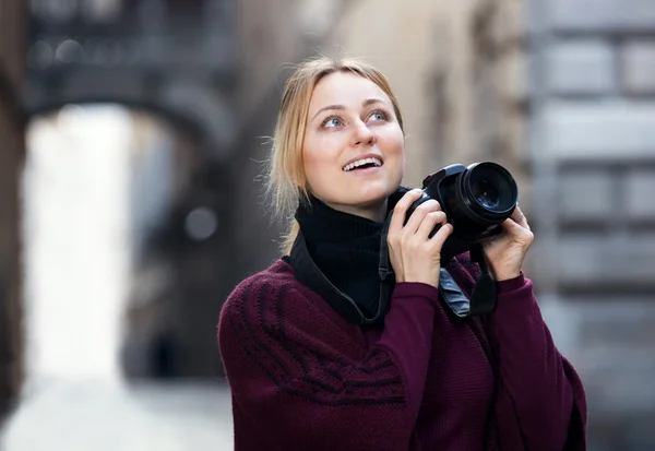 Girl holding camera in hands and photographing — Stock Photo, Image