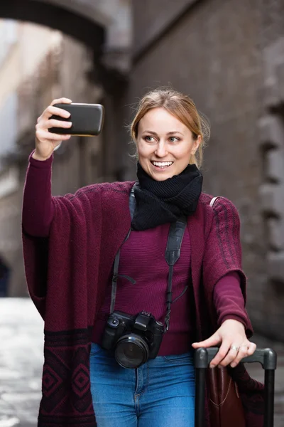 Menina tirando foto com seu telefone na cidade — Fotografia de Stock