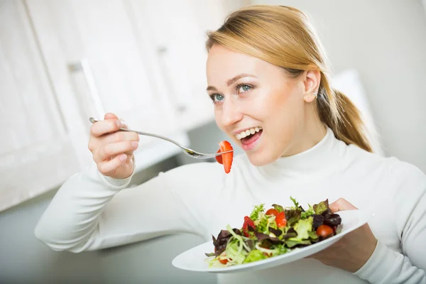 Cheerful blond girl eating salad — Stock Photo, Image