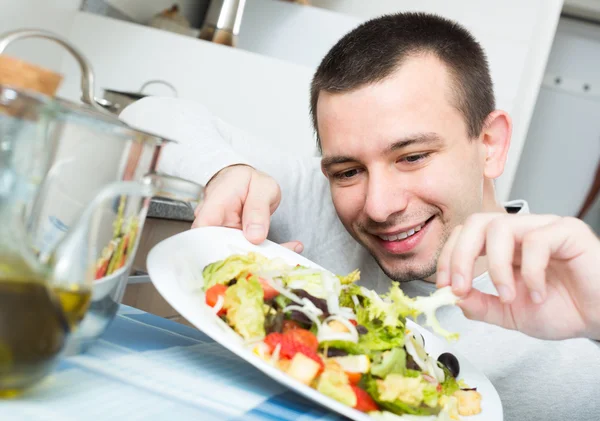 Guy decorating salad dish at home