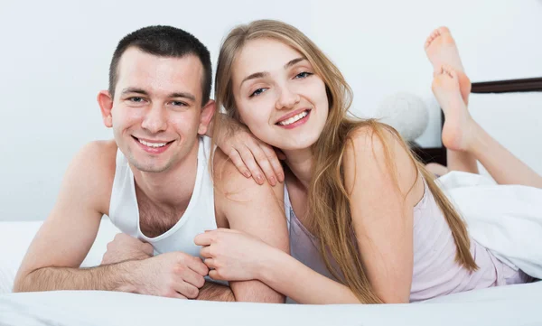 Young adults lying in family bed — Stock Photo, Image