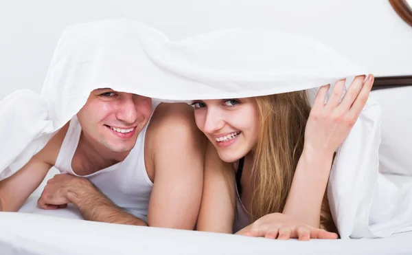 Couple lying under sheet — Stock Photo, Image