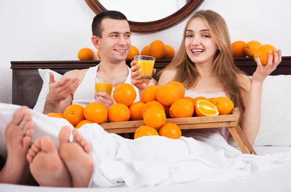 夫妇与成熟的橘子和新鲜果汁 — 图库照片