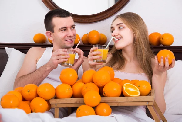 Мужчина и девушка пьют апельсиновый сок — стоковое фото