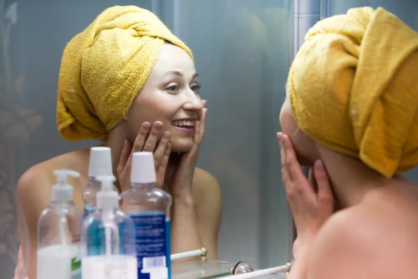 Vrouw kijken naar zichzelf in de spiegel — Stockfoto