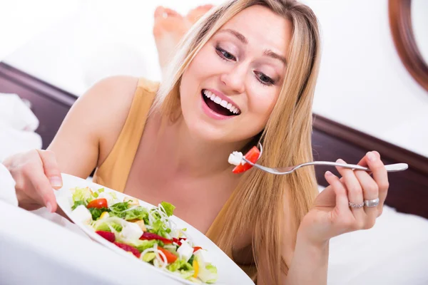 Vrouw in lingerie met salade Stockfoto