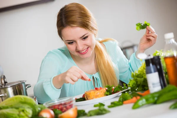 Ung kvinna decorating sallad — Stockfoto