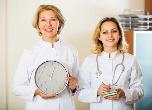 Duas médicas segurando relógio — Fotografia de Stock