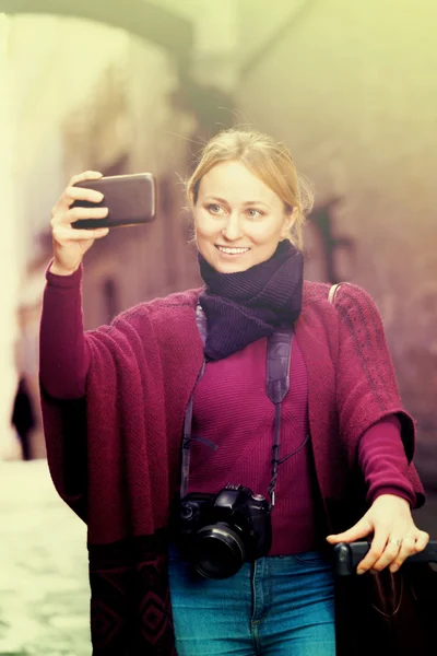 Menina tirando foto com seu telefone na cidade — Fotografia de Stock