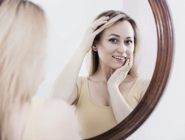 Jonge vrouw op zoek in spiegel — Stockfoto