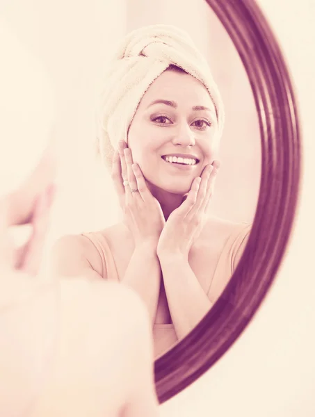 Woman standing next to mirror — Stock Photo, Image