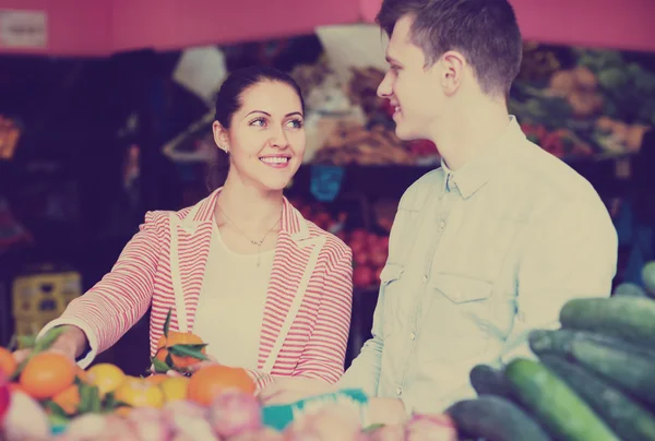 若いカップルが市場で果物を買う — ストック写真