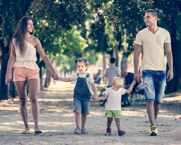 Famille avec deux petits enfants marchant dans le parc — Photo